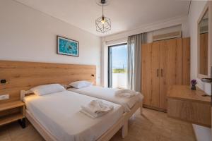 a bedroom with two beds and a large window at Anthia Apartments in Marmari