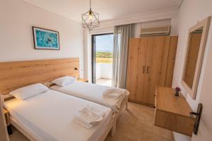 a bedroom with two beds and a window at Anthia Apartments in Marmari