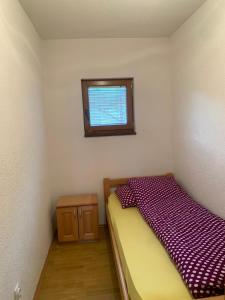 a small bedroom with a bed and a window at Guest House Šobić in Šipovo