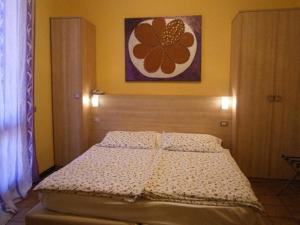 a bed in a bedroom with a flower painting on the wall at Hotel Chiara in Sirmione