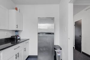 een keuken met een roestvrijstalen koelkast en witte kasten bij Lovely 2 Bedroom Condo Across from Horse Track condo in Hot Springs