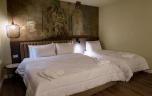 two beds in a room with a painting on the wall at Vila Borgjeze in Korçë
