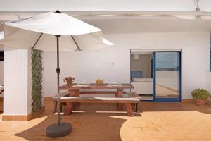 a picnic table with an umbrella in a room at Pérola do Atlântico By the Sea in Quarteira