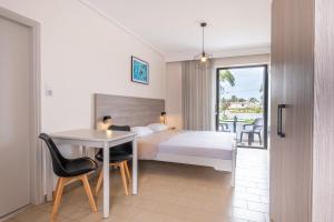 pokój hotelowy z łóżkiem, stołem i krzesłami w obiekcie Anthia Apartments w Marmari