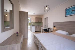 a bedroom with a large bed and a kitchen at Anthia Apartments in Marmari