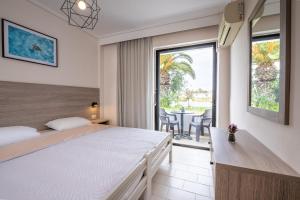 a bedroom with a bed and a balcony with a table at Anthia Apartments in Marmari