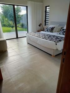 a bedroom with a bed and a large window at SANTOSHA in Tamarin
