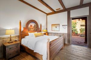 1 dormitorio con 1 cama grande con marco de madera en Adobe Village Inn, en Sedona