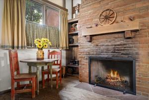 a fireplace in a living room with a table and a tableablish at Adobe Village Inn in Sedona