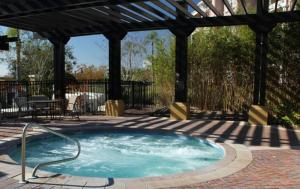 een hot tub in een patio met een prieel bij Penthouse Utopia condo in Orlando