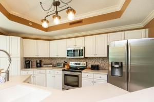 a kitchen with white cabinets and a stainless steel refrigerator at Phoenix on the Bay 1216 condo in Orange Beach