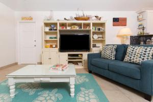 a living room with a couch and a tv at Coconut Beach by Grand Cayman Villas & Condos in Driftwood Village