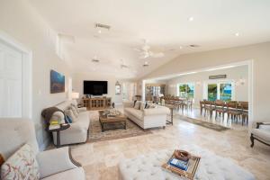 a living room with white furniture and a dining room at Fischers Reef by Grand Cayman Villas & Condos in Driftwood Village