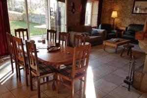 - une table et des chaises en bois dans le salon dans l'établissement Gîte au calme près nature Aubrac Margeride 3 étoiles, à Saint-Alban-sur-Limagnole