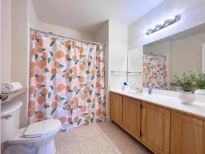 y baño con cortina de ducha, aseo y lavamanos. en 4 Bedroom Town Home Near Disney townhouse en Kissimmee