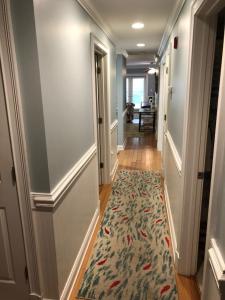 a hallway with a rug on the floor of a house at Unique 3BR, 1 of 5 Condos w/Huge Poolside Patio, Steps to Beach & Pier, Gated in Tybee Island