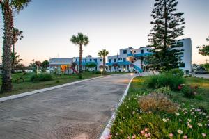 a street in front of a building with palm trees at Anthia Apartments in Marmari