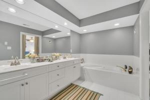ein weißes Badezimmer mit 2 Waschbecken und einer Badewanne in der Unterkunft Relaxing Luxurious Waterfront townhouse in Hampton