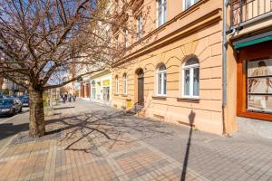 un arbre sur un trottoir à côté d'un bâtiment dans l'établissement Apartment Becherhaus, à Karlovy Vary