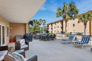 a large patio with chairs and tables on a balcony at Unique 3BR, 1 of 5 Condos w/Huge Poolside Patio, Steps to Beach & Pier, Gated in Tybee Island