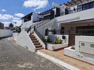 a white house with stairs in front of it at El Pisito La Dolce Vita in Puerto del Carmen