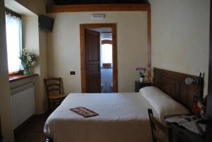 a bedroom with a bed and a table and a window at Agriturismo Il Talento Nella Quiete in Castiglione dʼIntelvi
