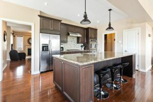 a kitchen with a large island with bar stools at Luxury Chalet-Walk to Beach/Village w Mtn View in Blue Mountains +37 photos