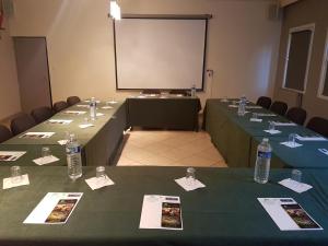 a conference room with two tables with bottles of water at Hôtel Aster Restaurant Aux Arcades in Briey