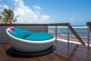a bath tub sitting on a deck next to the beach at Present Moment by Grand Cayman Villas & Condos in Bodden Town
