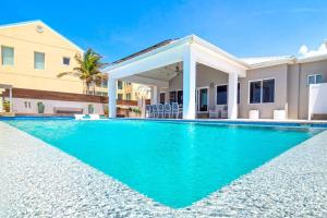 a swimming pool in front of a house at Present Moment by Grand Cayman Villas & Condos in Bodden Town