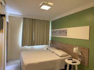 a hotel room with a bed and a table at Hotel Porto Grande in Maceió