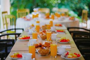 una mesa con platos de comida y vasos de zumo de naranja en El Encanto - Hotel Boutique, en Chichén Itzá