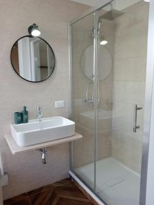 a bathroom with a sink and a shower with a mirror at FRABORGO in Corigliano Calabro +11 photos