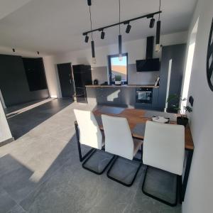 a kitchen and dining room with a table and chairs at Premium House Osztynek in Olsztynek