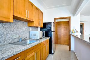 a kitchen with a sink and a refrigerator at Sunset View 2BR Apartamento Juan Dolio Las Velas in Juan Dolio