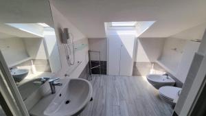 a bathroom with a sink and two toilets at Hotel Canoa in Cervia