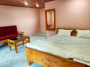 a bedroom with a bed and a table and a mirror at Rio De Vallis Eco Resort in Kalimpong