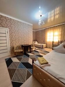 Гостиница NUR في Aralʼsk: غرفة نوم بسرير وطاولة واريكة
