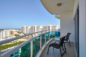 - deux chaises sur un balcon avec vue sur la ville dans l'établissement Sunset View 2BR Apartamento Juan Dolio Las Velas, à Juan Dolio
