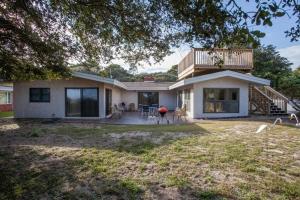 uma casa com uma varanda em cima em ROANOKE COTTAGE home em Jekyll Island