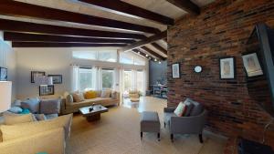 uma grande sala de estar com uma parede de tijolos em ROANOKE COTTAGE home em Jekyll Island