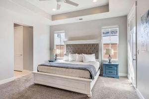 a bedroom with a bed with a blue nightstand and a window at The Ella home in Hurricane