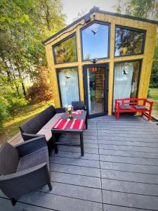 a tiny house with a table and chairs on a deck at Żurawi Dom in Srokowo