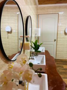 a bathroom with three sinks and a mirror at Hostal Treile in Pucón