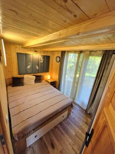 uma cama grande num quarto com pisos e janelas em madeira em Żurawi Dom em Srokowo