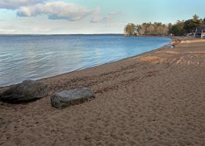 a beach with two rocks in the sand and water at COZY COVE COTTAGE LIMIT 6 cottage in Standish