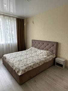 een slaapkamer met een groot bed met een getuft hoofdeinde bij Altair apartments Budova in Odessa