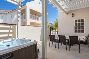 a patio with a hot tub and a table and chairs at Highlander townhouse in Hurricane