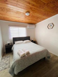 プコンにあるHostal Treileの木製の天井のベッドルーム1室(大型ベッド1台付)