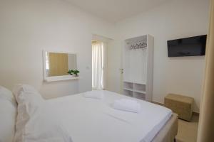 Relaxing Escape Rooms في كساميل: غرفة نوم بيضاء مع سرير أبيض ونافذة